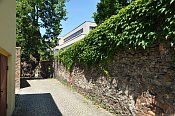 Odry – ohradní zeď v ul. Kostelní, v pozadí obchodní dům na místě zámku